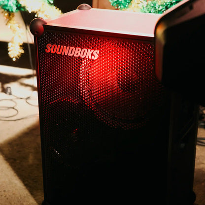 The Soundboks 4 on floor in red light#grillfarbe_metallgrau,en:grill-color_metallic-gray
