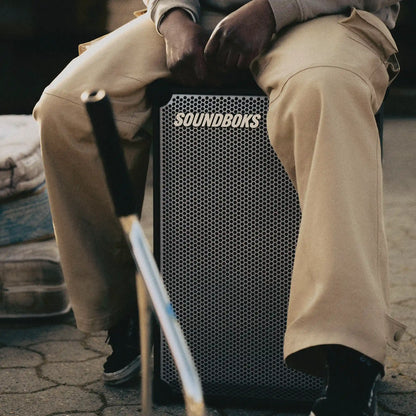 Person sitting on Metallic grey Soundboks 4.